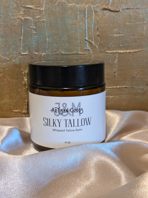 Jar of 'Silky Tallow' whipped balm on a textured surface with a gold background