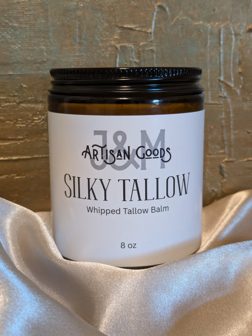 Jar of J&M Artisan Goods Silky Tallow Whipped Tallow Balm on a textured surface