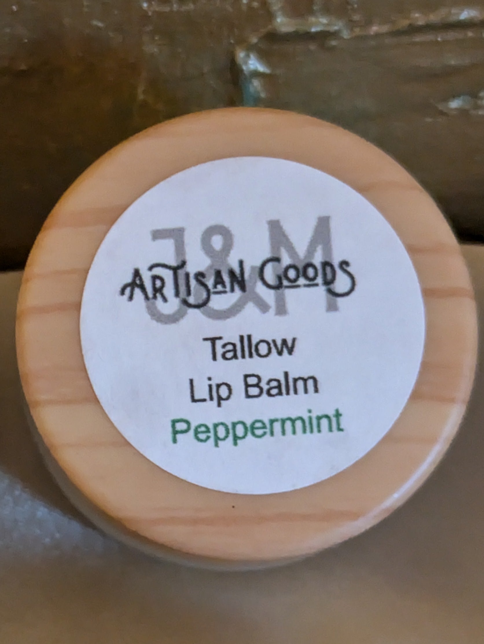 'J&M Artisan Goods' Peppermint Tallow Lip balm, with wooden lid.
